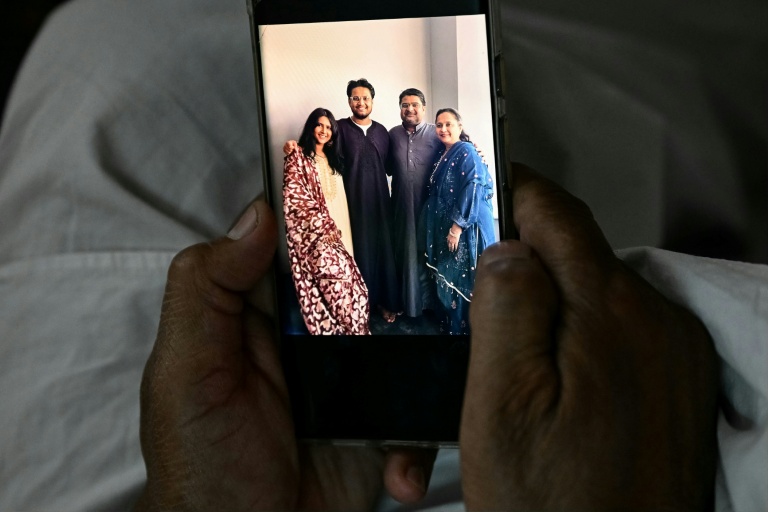 Badasab Saiyed, universitaire à la retraite, qui a perdu son frère, sa belle-sœur, son neveu et sa nièce dans le crash du vol 171 d'Air India, montre leur photo lors d'un entretien avec l'AFP à son domicile à Ahmedabad, le 11 novembre 2025 en Inde