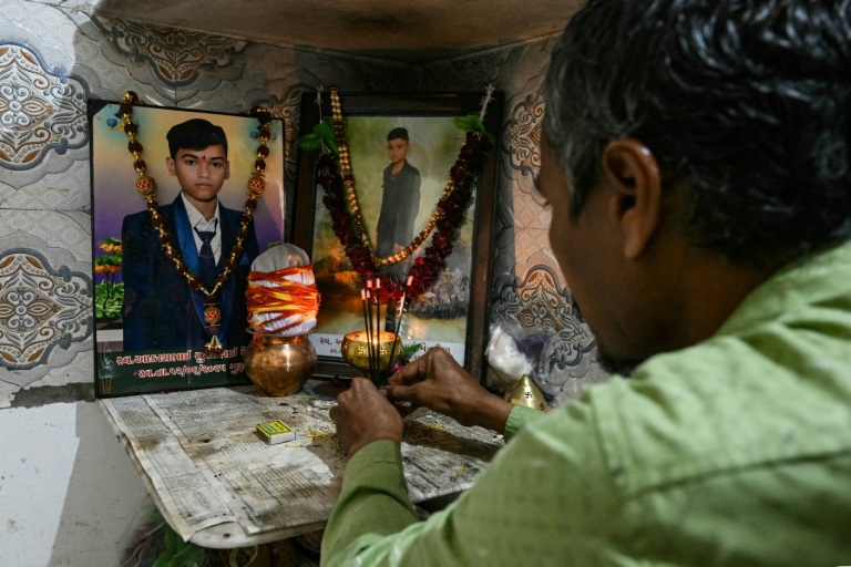 Suresh Patni, père d'Akash Patni, victime du crash du vol 171 d'Air India d'Air India, prie devant les portraits de son fils à son domicile d'Ahmedabad, le 8 novembre 2025 en Inde