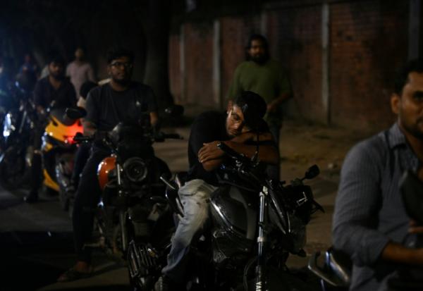 Un homme fait la sieste sur sa moto dans une file d'attente pour du carburant à Dacca, capitale du Bangladesh, le 21 avril 2026