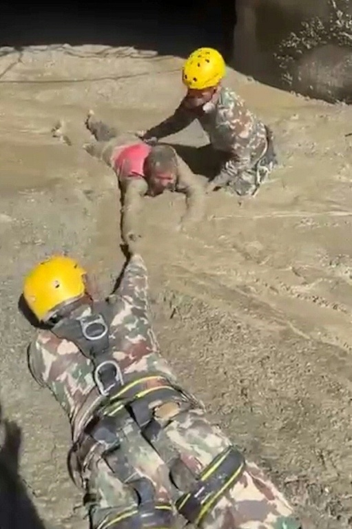Cette capture d’écran, extraite d’une vidéo fournie par un vidéaste amateur et diffusée par le secrétariat du Premier ministre du Népal le 28 août 2026, montre l’Armée népalaise en train de secourir une personne coincée à l’intérieur d’un tunnel d’un projet hydroélectrique après la crue