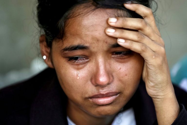 Une femme pleure après avoir été secourue dans un camp militaire à la suite des crues soudaines, dans la ville de Battar Bazar, district de Nuwakot au Népal, le 28 août 2026