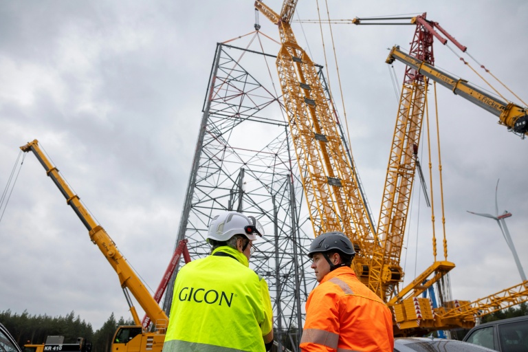 Jochen Grossmann, à gauche, PDG du groupe GICON, et le chef de projet Frank Adam, à sa droite, devant le chantier de la plus haute éolienne du monde à Schipkau, en Allemagne, le 13 mai 2026
