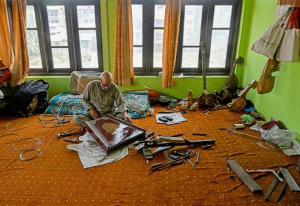L'artisan Ghulam Mohammad Zaz fabrique un santour, un instrument à cordes ancestral, dans son atelier à Srinagar, le 23 septembre 2025 au Cachemire indien