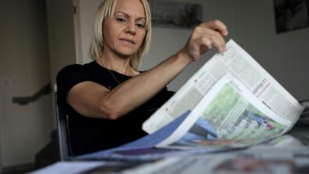 La Marocaine Yasmina Tellal, consulte des coupures de presse, dans le sud-ouest de la France, le 15 août 2025