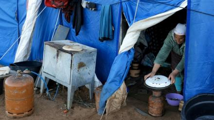 Une femme prépare à manger dans l'une des tentes d'un camp destiné aux personnes touchées par les inondations qui ont frappé le nord et l'ouest du Maroc, dans la région de Kénitra, le 20 février 2026