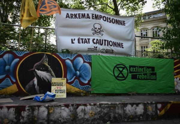 Une banderole indique "Arkema empoisonne, l'Etat soutient" lors d'un rassemblement devant le palais de justice de Lyon en soutien à des activistes poursuivis après une action anti-pollution en mars contre l'usine du chimiste Arkema, le 18 juin 2024