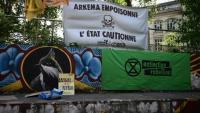 Une banderole indique "Arkema empoisonne, l'Etat soutient" lors d'un rassemblement devant le palais de justice de Lyon en soutien à des activistes poursuivis après une action anti-pollution en mars contre l'usine du chimiste Arkema, le 18 juin 2024