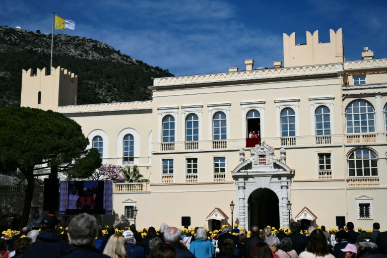 Des fidèles dans la cour du palais princier de Monaco écoutent le pape Léon XIV qui s'exprime depuis le balcon, le 28 mars 2026 