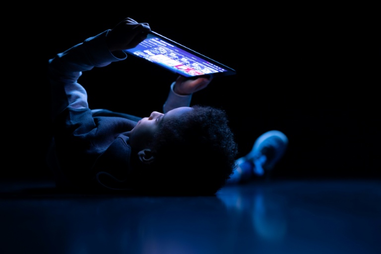 Un enfant regarde une tablette à Paris, le 14 février 2024.