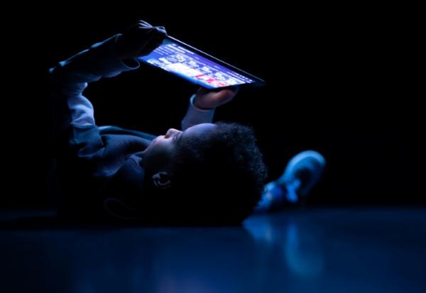 Un enfant regarde une tablette à Paris, le 14 février 2024.
