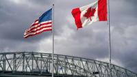 Les drapeaux américain et canadien près du poste frontalier du pont Blue Water à Point Edward, en Ontario, le 24 octobre 2025 au Canada
