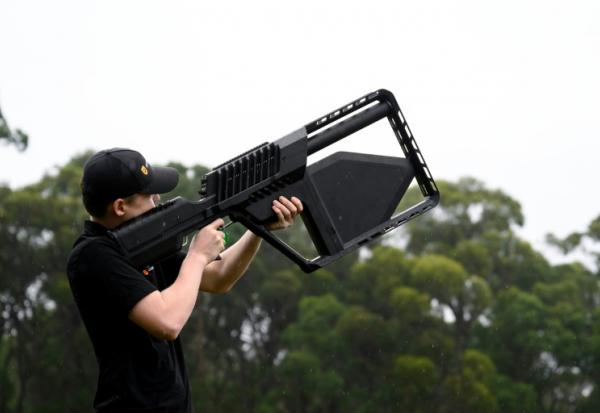 Un membre de l'équipe DroneShield tient un fusil "DroneGun" à Sydney, le 9 février 2026 en Australie