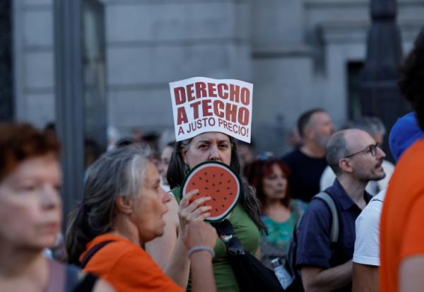 Un manifestant tient une pancarte portant l'inscription « Droit à un toit à un prix équitable » lors d'une manifestation contre les expulsions et la crise du logement sur la Puerta del Sol à Madrid, le 26 septembre 2026