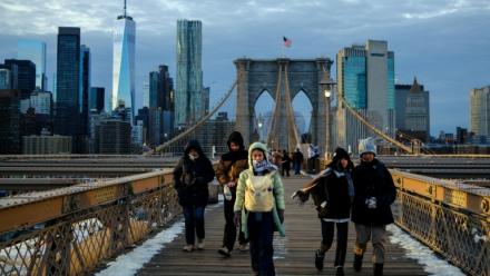 Des passants bravent le froid en traversant le pont de Brooklyn, dans le quartier de Manhattan à New York, le 21 janvier 2026