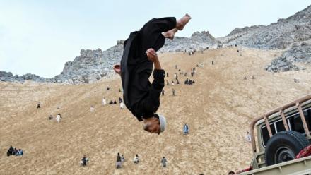 Un Afghan exécute un salto à l'arrière d'un véhicule sur la montagne Reg-e-Rawan dans la région de Sayad, le 24 avril 2026, en Afghanistan