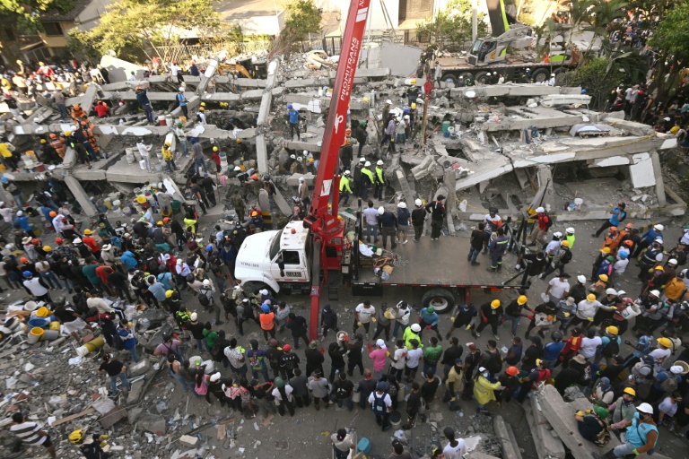 Secouristes et bénévoles à l'oeuvre près d'un immeuble en ruines après un puissant séisme, à Cali en Colombie, le 11 août 2026 