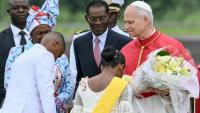 Le pape Léon XIV (à droite) reçoit des fleurs d'enfants alors qu'il est accueilli par le président de Guinée équatoriale Teodoro Obiang Nguema Mbasogo (au centre) à son arrivée à l'aéroport international de Malabo à Malabo le neuvième jour d'un voyage apostolique de 11 jours en Afrique, le 21 avril 2026.