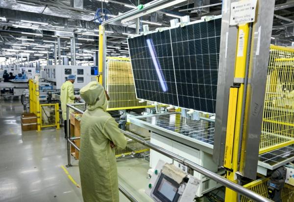 Des employés dans une usine de panneaux solaires du groupe Adani à Mundra, dans l'ouest de l'Inde, le 5 novembre 2025 
