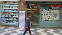 Une Iranienne passe devant une boutique de téléphonie mobile, le 19 avril 2026 à Téhéran