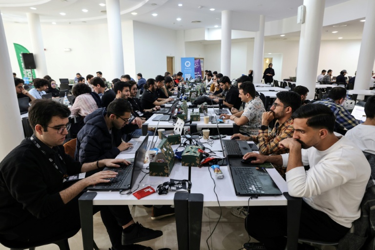 Des étudiants iraniens préparent des projets liés à l'intelligence artificielle lors de la deuxième édition des Olympiades de la Tech au parc technologique de Pardis en Iran, en périphérie de Téhéran, le 28 octobre 2025