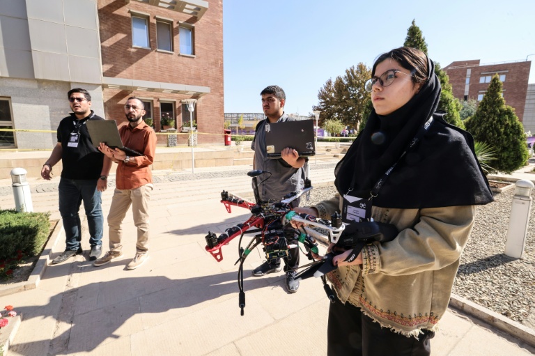 Une étudiante iranienne teste un drone lors de la deuxième édition des Olympiades de la Tech au parc technologique de Pardis en Iran, en périphérie de Téhéran, le 28 octobre 2025