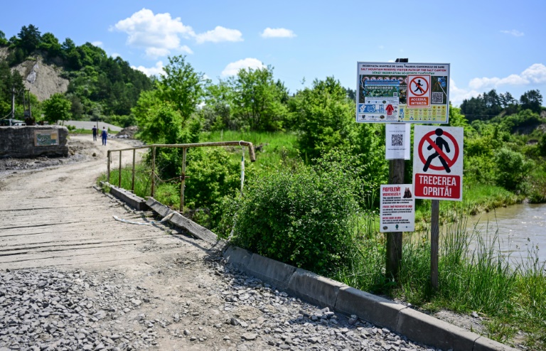 Panneaux défense d'entrée devant le pont enjambant la rivière Corund et menant à la mine de sel de Praïd, en Roumanie, le 3 juin 2025