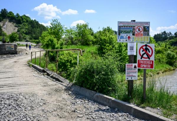 Panneaux défense d'entrée devant le pont enjambant la rivière Corund  et menant à la mine de sel de Praïd, en Roumanie, le 3 juin 2025