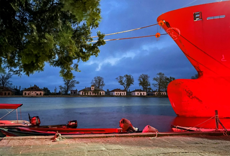 Un navire à l'ancre est illuminé par une lumière rouge utilisée pendant la nuit pour la navigation, à Sulina, le 9 mai 2026, en Roumanie