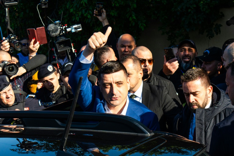 Le chef du parti nationaliste AUR et candidat à la présidence roumaine, George Simion, salue ses partisans après avoir voté à Mogosoaia, près de Bucarest, le 18 mai 2025