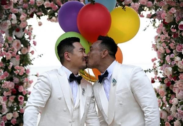 Les Chinois Song Jihan (g) et Wang Zengyi s'embrassent lors de la cérémonie de leur mariage près de Pattaya, dans la province de Chonburi, le 31 mai 2025 en Thaïlande