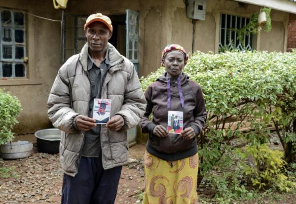 Moses Muyela et Josephine Ngoya, les parents d'Erastus Mundia, montrent des photos de leur fils, chez eux à Nabemo, au Kenya, le 27 février 2026