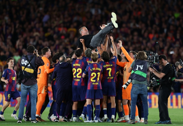 L'entraineur du Barça Hansi Flick porté en triomphe par ses joueurs après la victoire dans le Clasico face au Real Madrid, synonyme de titre de champion d'Espagne, le 10 mai 2026 au Camp Nou
