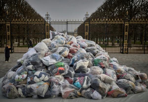 Des sacs de déchets textiles devant la porte du Palais du Luxembourg, où se trouve le Sénat lors d'une manifestation contre la fast-fashion, à Paris, le 14 mars 2025