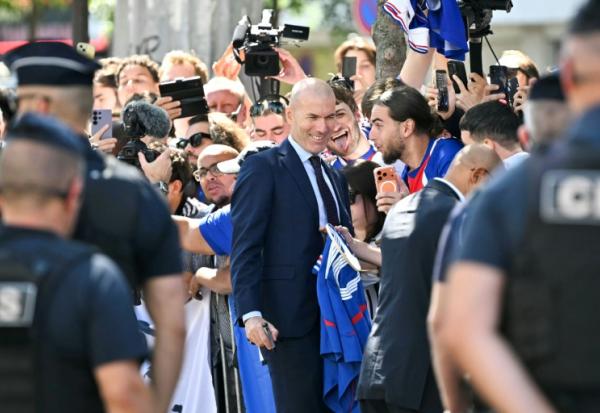 Le nouveau sélectionneur de l'équipe de France Ziénédine Zidane prend des photos avec les supporters devant le siège de la FFF, le 28 juillet 2026 à Paris