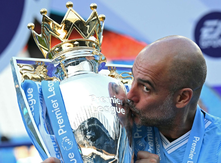 Pep Guardiola embrasse le trophée de la Premier League, le 19 mai 2024 à l'Etihad Stadium