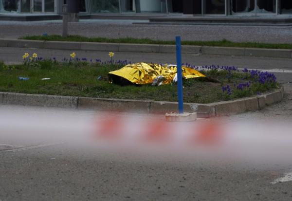 Le corps d'un civil gît au sol, caché par une couverture, après une frappe russe à Kiev, le 16 avril 2026