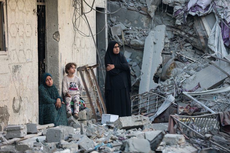 Des femmes et un enfant au milieu des décombres d'une maison détruite lors d'une frappe israélienne nocturne à Gaza, le 29 octobre 2025