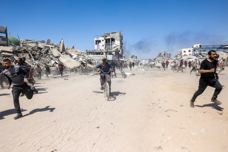Des Palestiniens courent pour se mettre à l'abri lors d'une frappe de drone israélien à Jabalia, dans le nord de la bande de Gaza, le 23 mai 2025