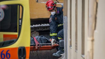 Des secouristes transportent le corps d'une personne retrouvée sous les décombres après l'effondrement d'un immeuble à Athènes, le 26 septembre 2026 