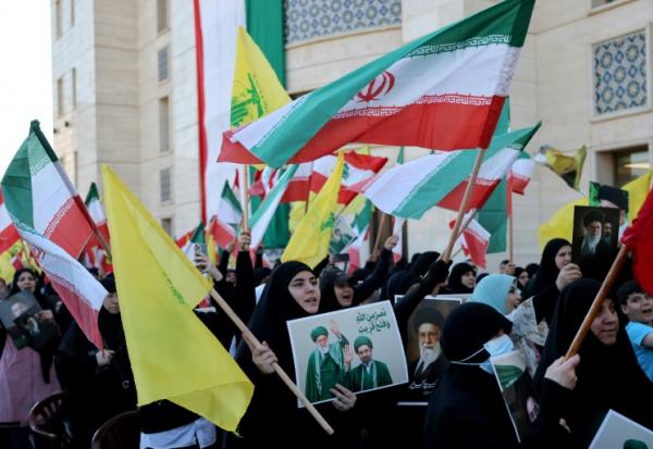 Des manifestants brandissent des drapeaux du Hezbollah, de l'Iran et du Liban, ainsi que des portraits du Guide suprême iranien, Mojtaba Khamenei, lors d'une cérémonie commémorative à Beyrouth, le 22 avril 2026, en l'honneur du Guide suprême iranien assassiné, l'ayatollah Ali Khamenei