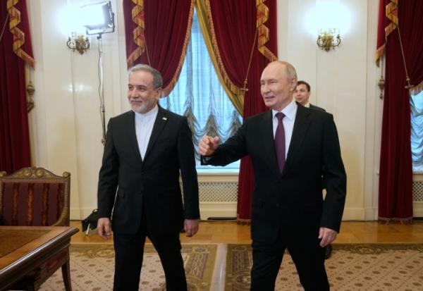 Le président russe Vladimir Poutine (d) et le ministre iranien des Affaires étrangères Abbas Araghchi à Saint-Pétersbourg, le 27 avril 2026 en Russie