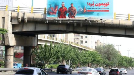 Une affiche anti-américaine sur laquelle est écrit en persan "Nos canons sont pleins" en référence au détroit d'Ormuz, déployée sur un pont au-dessus d'une autoroute à Téhéran, le 12 mai 2026