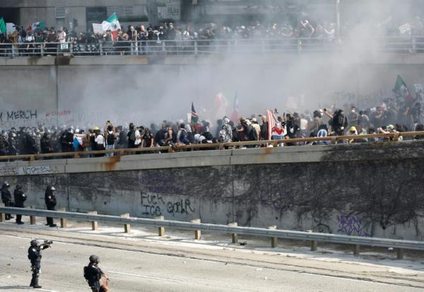 Des membres des forces de l'ordre tentent de déloger des manifestants bloquant une autoroute, à Los Angeles, le 8 juin 2025