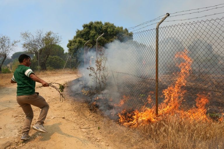 Un habitant essaie d'éteindre un incendie sur sa propriété près de San Martin de Valdeiglesias, à environ 70 km à l'ouest de Madrid, le 26 juillet 2026