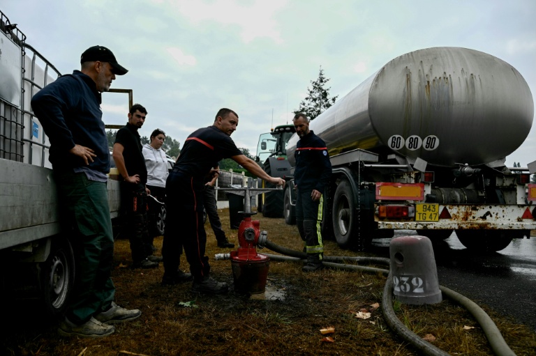 Des agriculteurs aident les pompiers à remplir des citernes pour lutter contre l'incendie en Gironde, à Blagon, à l'ouest de Bordeaux, le 27 juillet 2026
