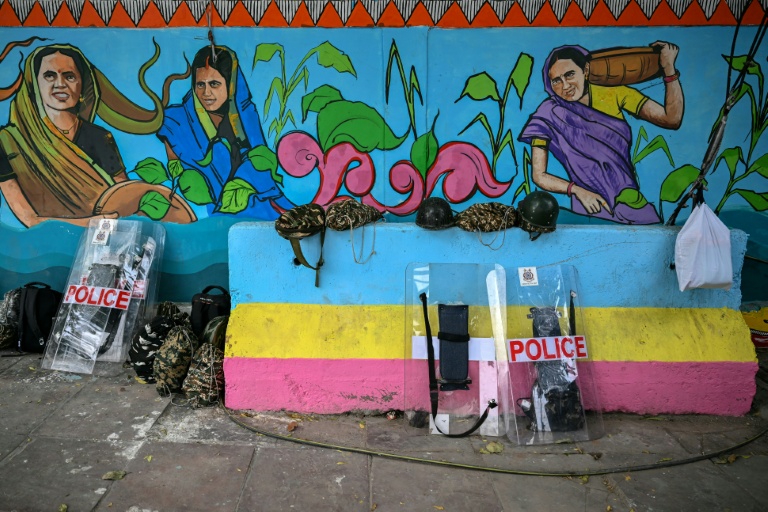Des boucliers de la police déposés devant une fresque lors d'une manifestation à New Delhi, en Inde, le 11 octobre 2026