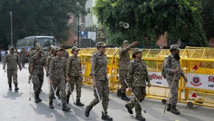 Les membres des forces de sécurité arrivent pour prendre leur poste à un point de contrôle temporaire à New Delhi, le 11 octobre 2026