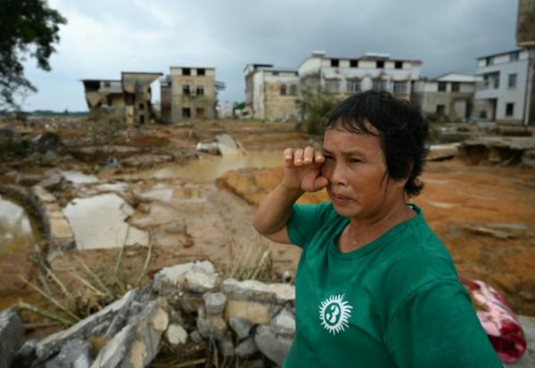 Une femme examine les dégâts dans le village de Liulan, inondé lorsqu'un réservoir s’est effondré dans la ville de Hengzhou, dans la région du Guangxi, au sud-ouest de la Chine, le 8 juillet 2026