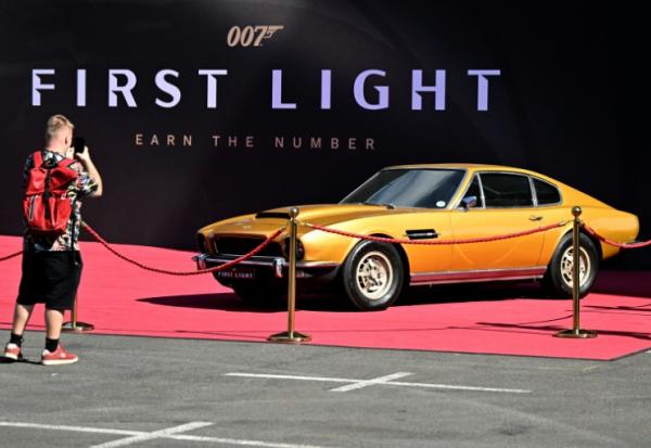  Un visiteur prend en photo une Aston Martin sur le stand du jeu vidéo 007 First Light d'IO Interactive lors du salon Gamescom à Cologne, le 21 août 2025 en Allemane