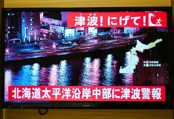 Un avertissement indiquant "Tsunami ! Courez !" (en haut) et "Alerte au tsunami émise pour la côte Pacifique du centre de Hokkaido" s'affiche sur un écran de télévision à Sapporo, au Japon, le 9 décembre 2025